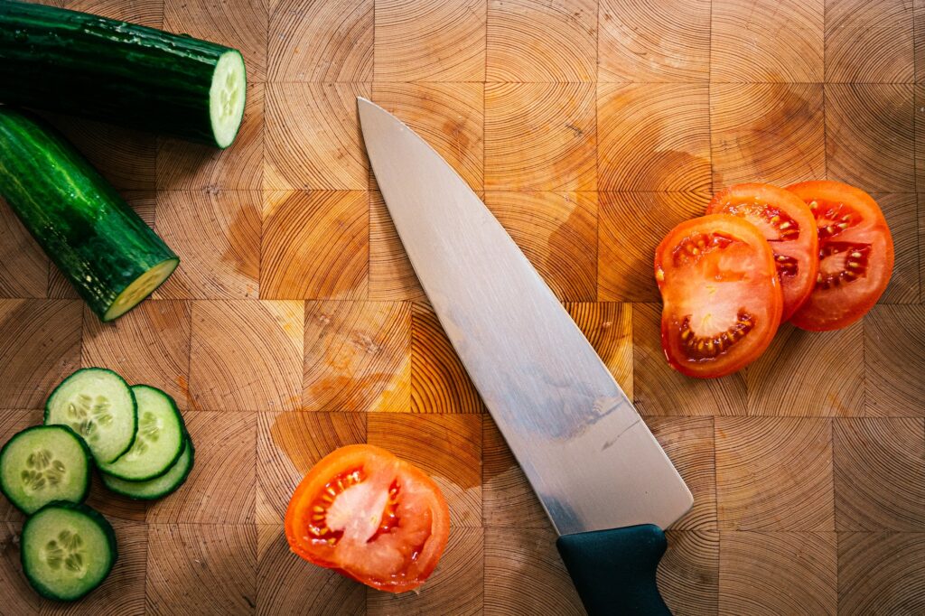 How should you stand at your cutting board for efficiency?